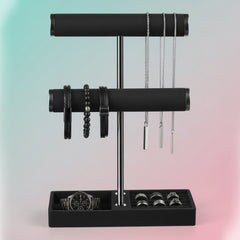 Black 2‑tier velvet jewelry display stand holding bracelets, necklaces, rings, and a watch on a modern organizer base.