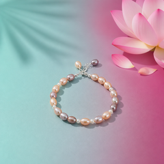 Mixed‑color freshwater pearl bracelet with lavender, peach, and white pearls arranged in a circle on a soft aqua‑mint and lotus‑magenta background with a lotus flower accent.