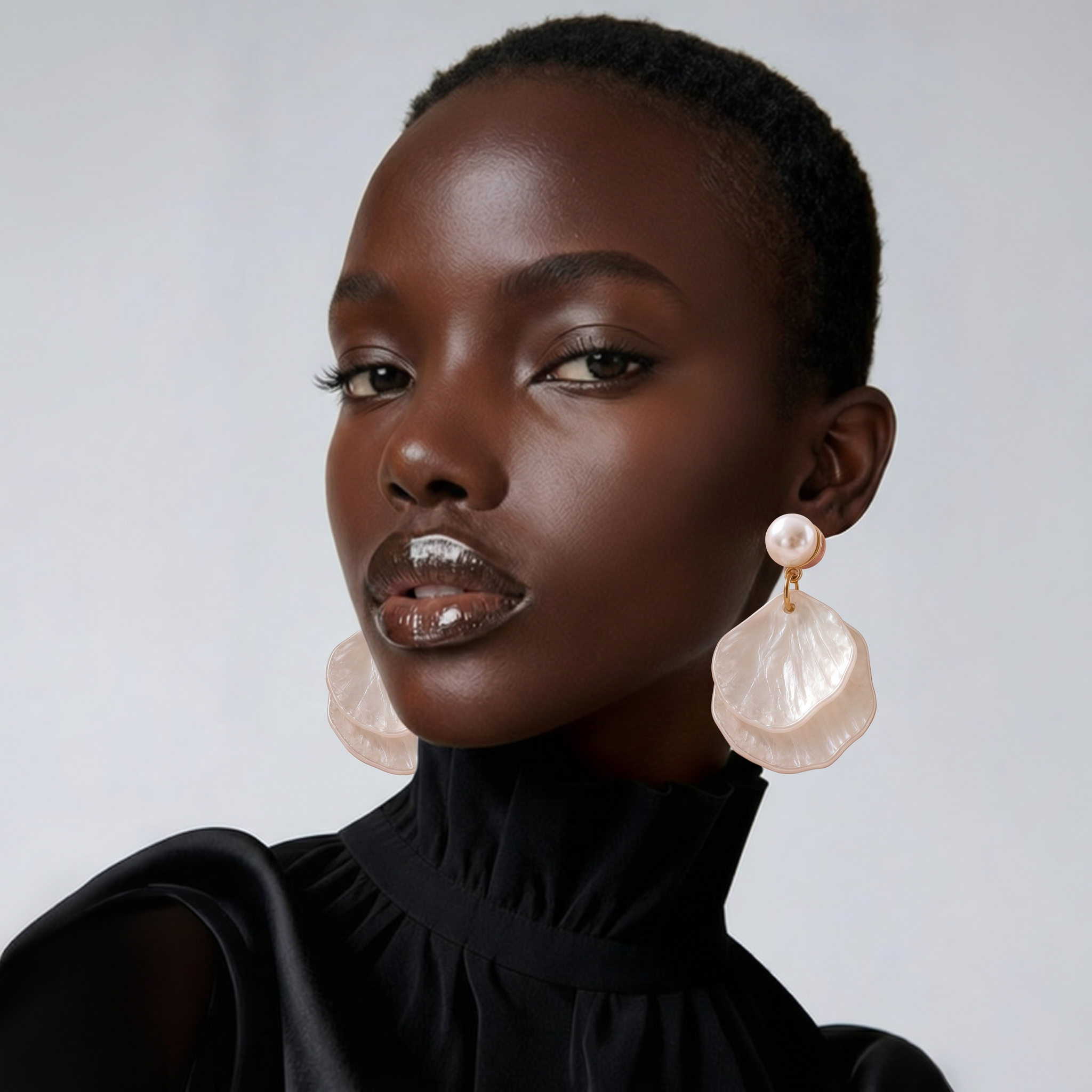 Woman wearing large, pink earrings against a neutral background